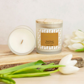 Serene Oasis Golden Sand Botanical Vines Scented Candle Front View, Inside View, Sitting On A Piece Of Wood With Tulips Around It