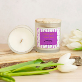 Serene Oasis Violet Botanical Vines Scented Candle Front View, Inside View, Sitting On A Piece Of Wood With Tulips Around It