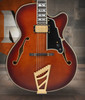 Dâ€™Angelico Single Cutaway Hollowbody guitar in Amaretto Burst featuring a full hollow archtop body, vintage-inspired appointments, dual humbuckers, wooden bridge styling, and includes a matching hard case.