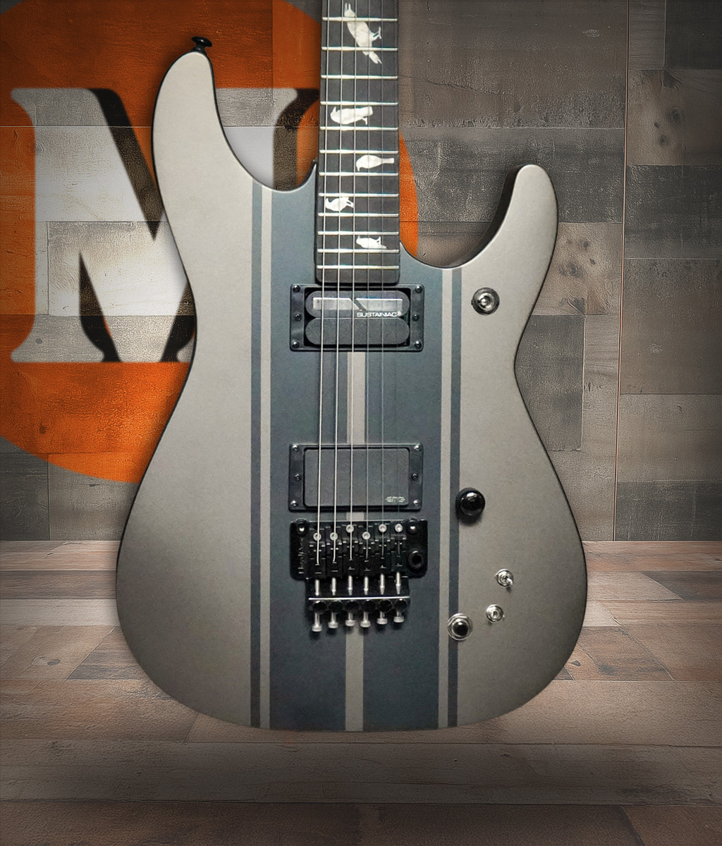 The Schecter DJ Ashba Electric Guitar (270) features a sleek Carbon Grey finish and signature design appointments inspired by Ashbaâ€™s high-energy performance style. Equipped with powerful pickups, a fast neck profile, and performance-ready hardware, this guitar delivers aggressive tone, smooth playability, and standout aesthetics ideal for rock and metal players.