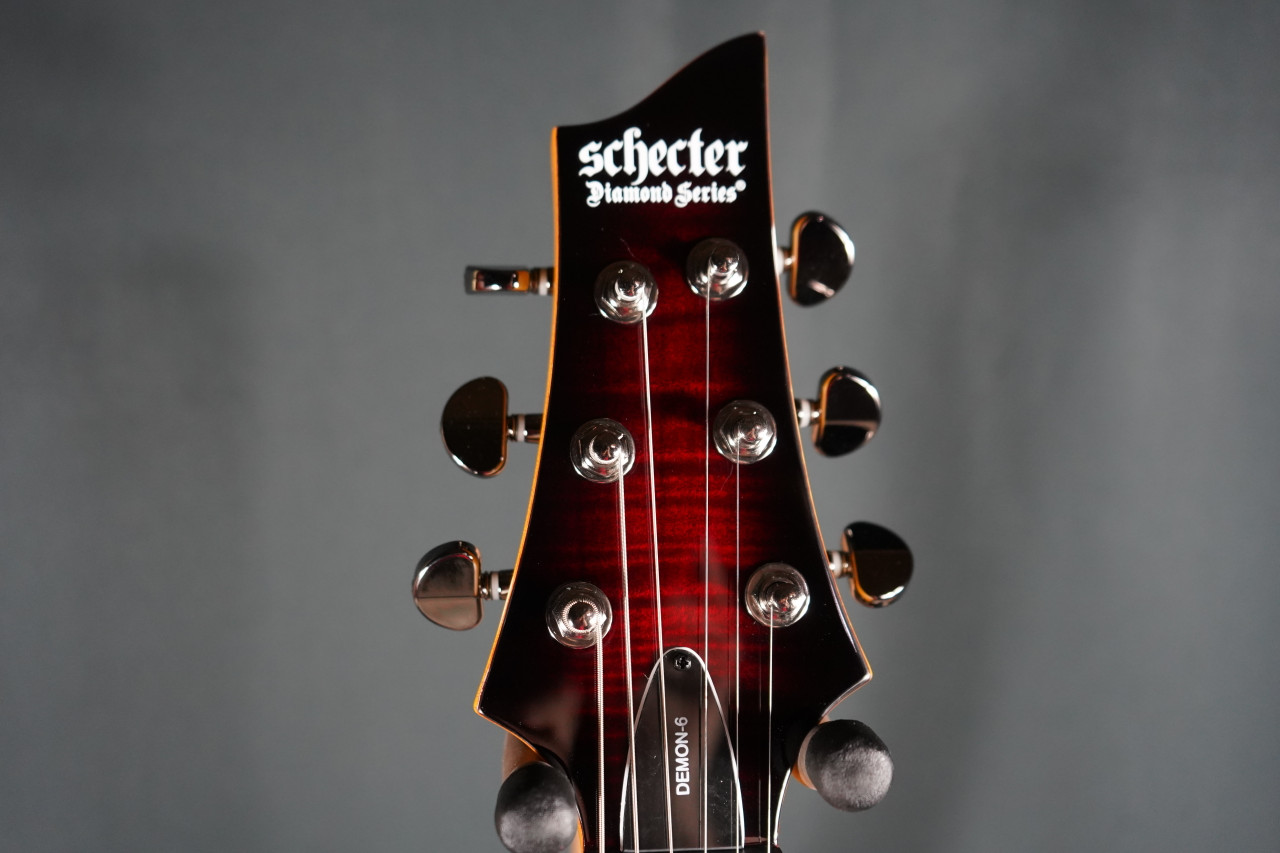 Schecter Demon-6 Electric Guitar - Crimson Red Burst finish, solid-body design with Schecter Diamond Active pickups, arched top, and sleek black hardware for modern metal tone