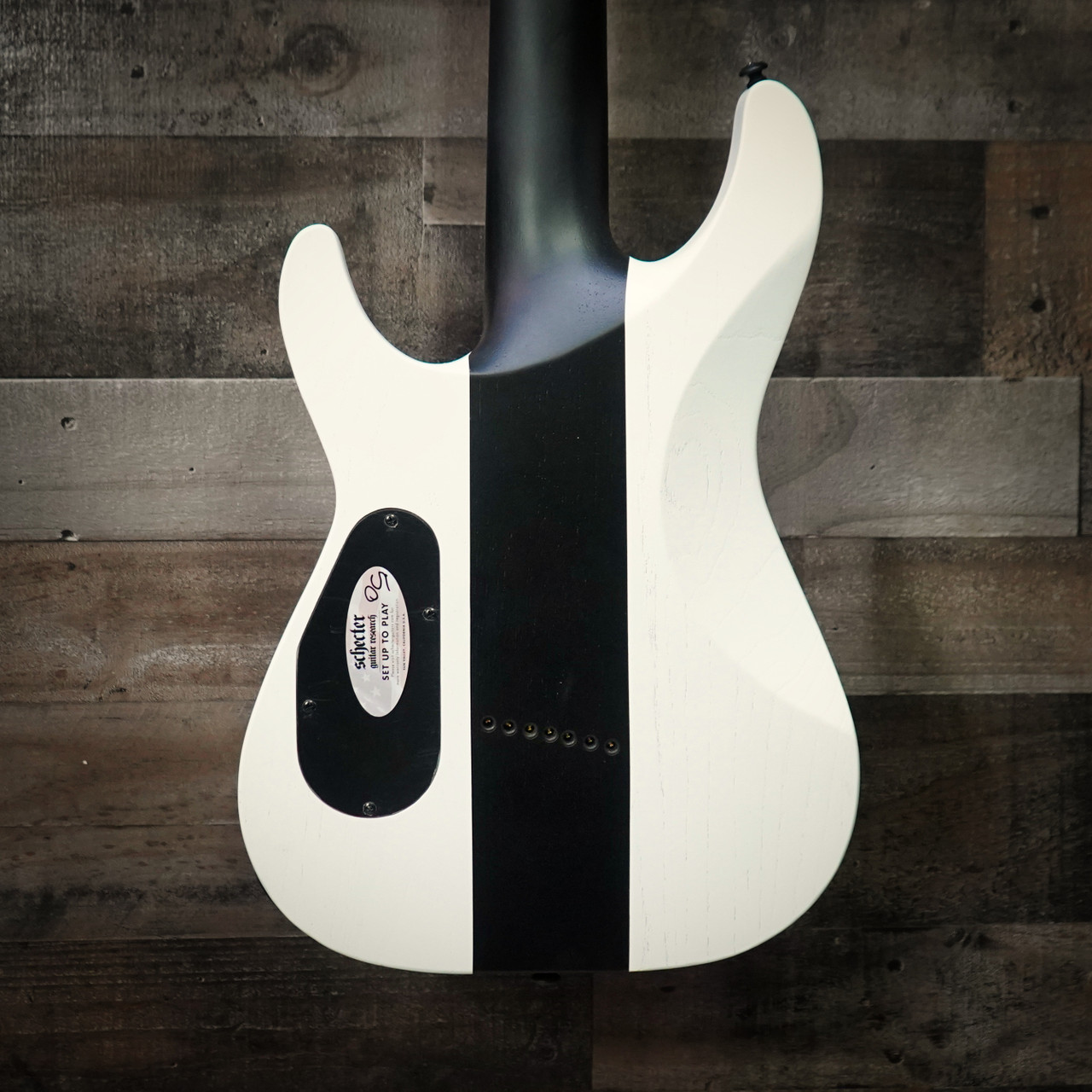 Schecter C-7 Contrasts Rob Scallon 7-String Multiscale guitar featuring a dual white/black finish, multi-scale ebony fingerboard, signature pickups, lightweight body, and signature Rob Scallon design elements.