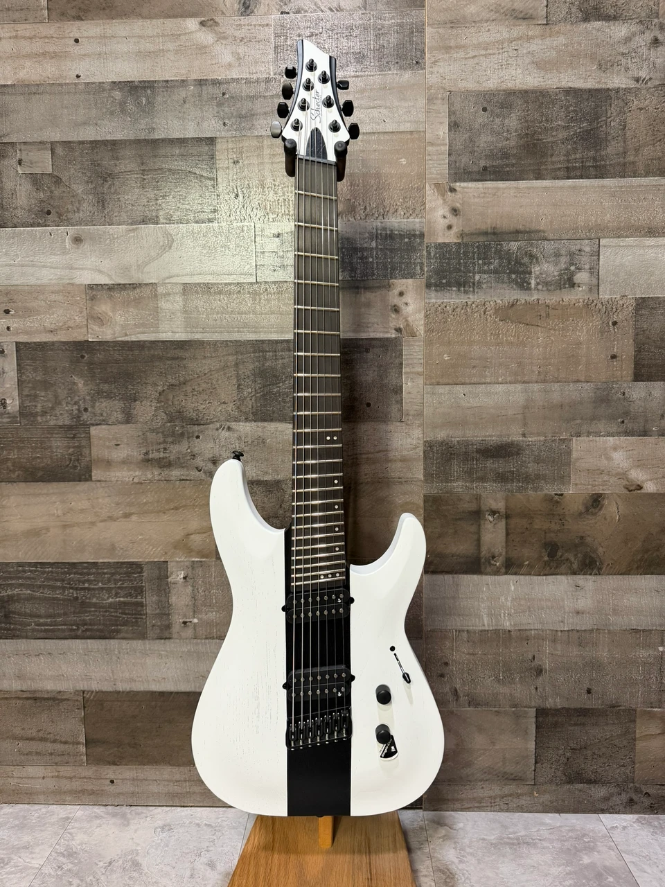 Schecter C-7 Contrasts Rob Scallon 7-String Multiscale guitar featuring a dual white/black finish, multi-scale ebony fingerboard, signature pickups, lightweight body, and signature Rob Scallon design elements.