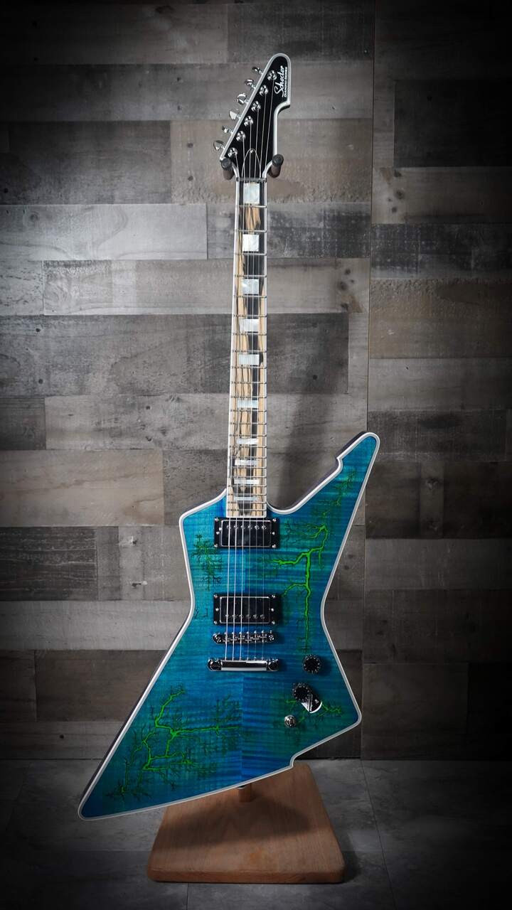 The Schecter E-1 Electro Resin (603) showcases a unique Yellow Electro Resin/Natural finish over a dramatically shaped E-1 body. Its eye-catching resin top provides a boutique look, while the lightweight body and thin-C neck ensure fast, comfortable playability. Equipped with powerful Schecter humbuckers, this guitar delivers tight lows, cutting highs, and excellent sustainÃ¢â‚¬â€ideal for modern rock, metal, and players wanting a standout stage instrument.