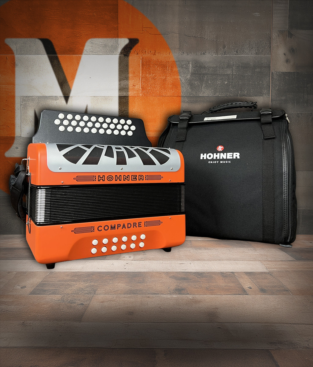 The Hohner Compadre FBbEb diatonic accordion in orange with a silver grille includes a gig bag and delivers bright tone and durability for norteÃƒÂ±o and conjunto styles. Available at Musician Madness.