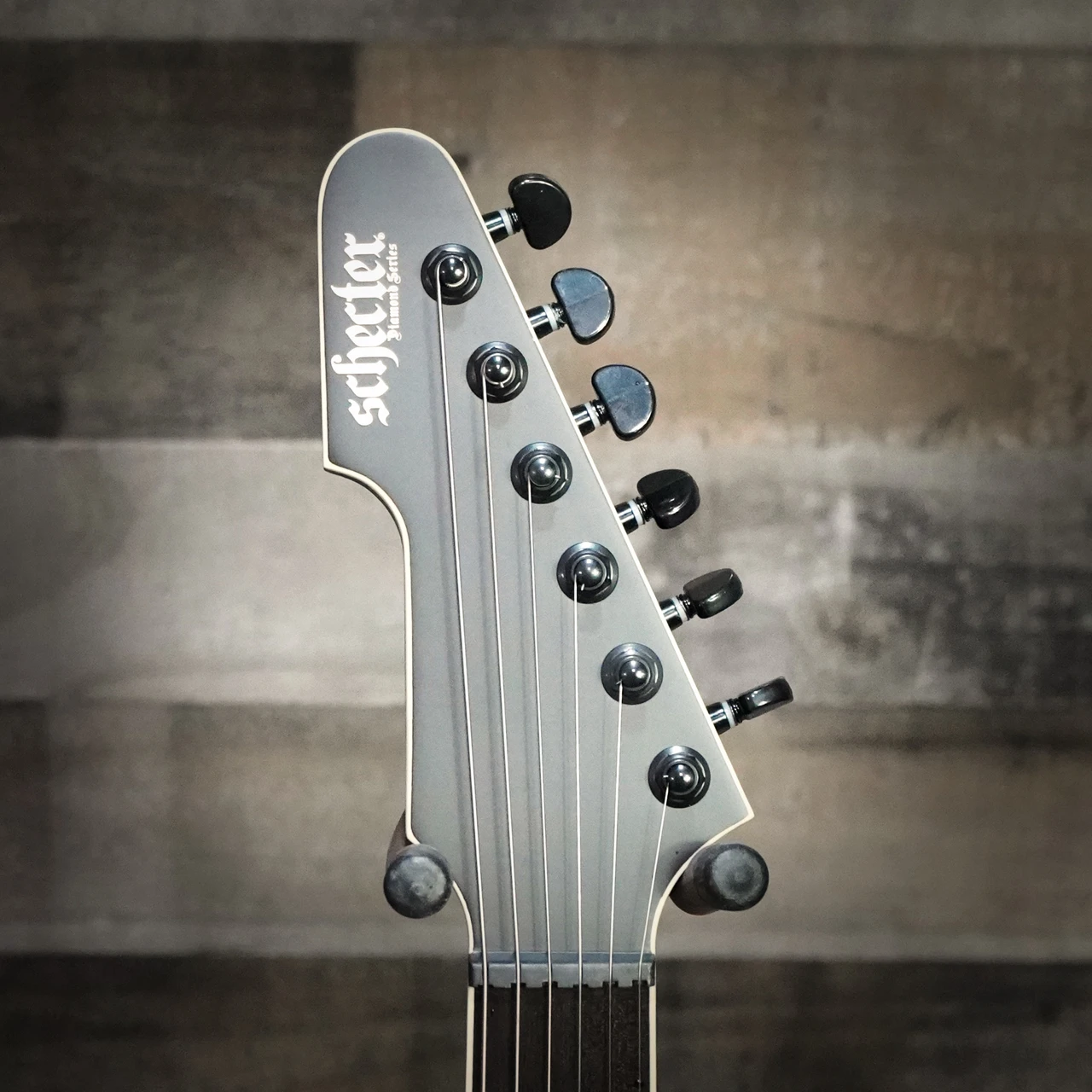 Schecter E-1 SLS Evil Twin electric guitar in Satin Black featuring an angular body design, ultra-thin neck profile, high-output humbuckers, premium SLS construction, and modern blacked-out hardware.