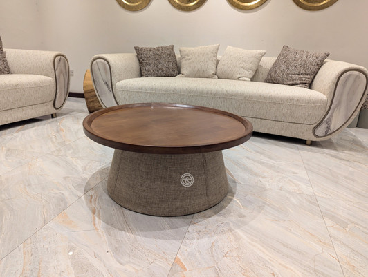 Circular center table in walnut finish with canvas textural detail over a solid wooden frame