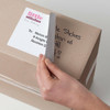 Close up of shipping label applied to parcel showing clean coverage over old markings