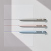 Uni-ball Zento pens in fog grey, adobe pink, and cloud blue barrels writing fine lines on white paper