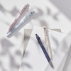 Uni-ball Zento pens in lavender, cloud blue, ivory, and indigo barrels arranged on white surface with shadows