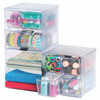 Multiple clear stackable drawer cubes arranged together and filled with stationery, showing the modular storage system in use.