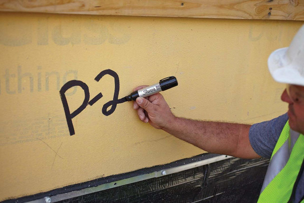 Worker marking wood surface with Sharpie Pro Magnum black marker