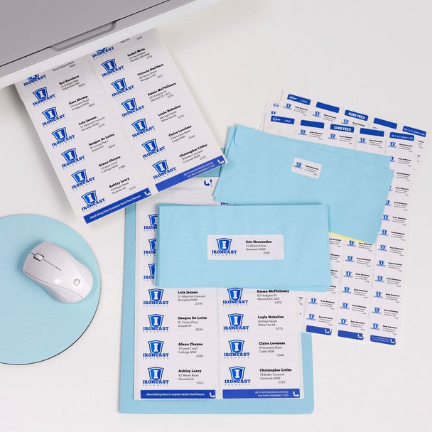 Desk flat lay showing printed address labels on sheets for mail merge style labelling