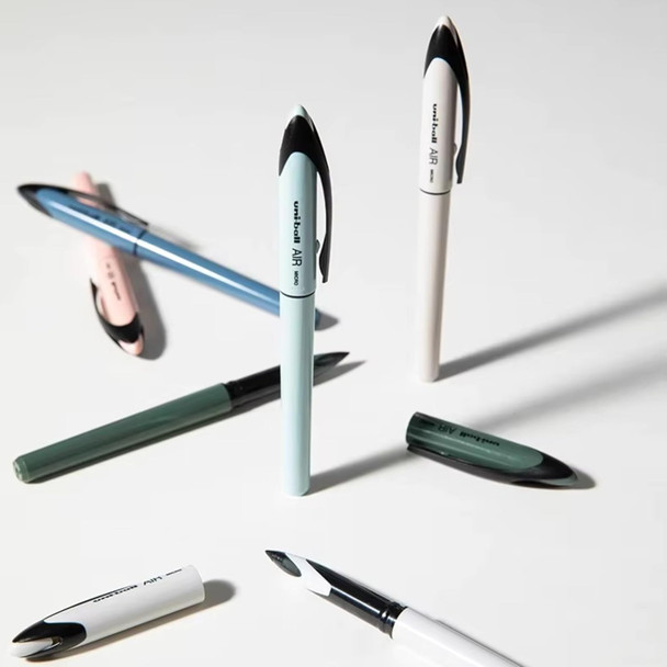 Set of five Uni-ball Air Micro pastel barrel pens in assorted colours arranged on white surface Set of five Uni-ball Air Micro pastel barrel pens in assorted colours arranged on white surface