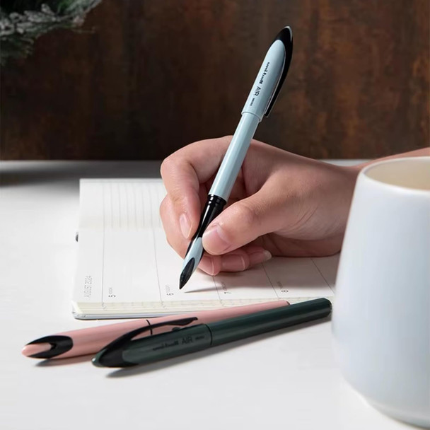 Person writing in notebook with Uni-ball Air Micro ice blue pastel barrel pen, sandstone and moss green pens beside Person writing in notebook with Uni-ball Air Micro ice blue pastel barrel pen, sandstone and moss green pens beside