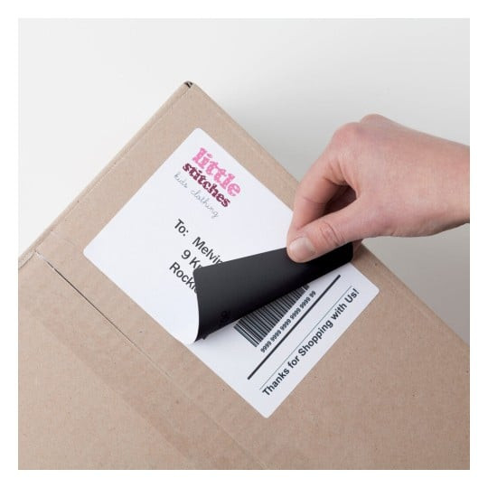 Avery TrueBlock label being peeled back to show coverage over an existing label on a carton