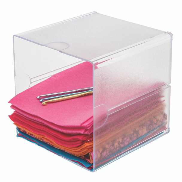 Clear open storage cube holding folded papers and stationery, showing practical desktop organisation.