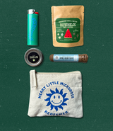 Flat lay of tealight candle, pre-roll, lighter, 5ct Watermelon gummies, and Merry Little Microdose pouch arranged neatly on green background.