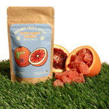 Redeemer Small Batch Blood Orange THC + CBG Gummies pouch with sliced blood oranges and gummies on grass, organic vegan hemp edibles Redeemer Small Batch Blood Orange THC + CBG Gummies pouch with sliced blood oranges and gummies on grass, organic vegan hemp edibles