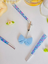 Blue silicone bow J clip with silver metal claws for holding a cigarette or pre-roll.