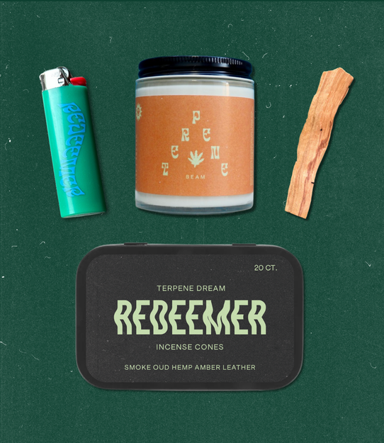 Flat lay of BEAM candle, Redeemer incense tin, palo santo, and branded lighter on a green textured backdrop.