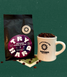 Flat lay of Try Hard coffee bag and Redeemer ceramic mug filled with coffee beans on a green background.