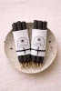 Cosmic Provisions Black Copal hand rolled incense bundles arranged on a speckled ceramic tray.