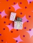 Open pink Lobotobaby lighter with the flip-top lid raised, revealing the metal ignition mechanism and star-patterned design.