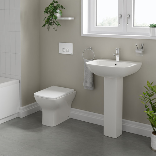 A modern basin and pedestal with back to wall toilet including concealed cistern and flush plate