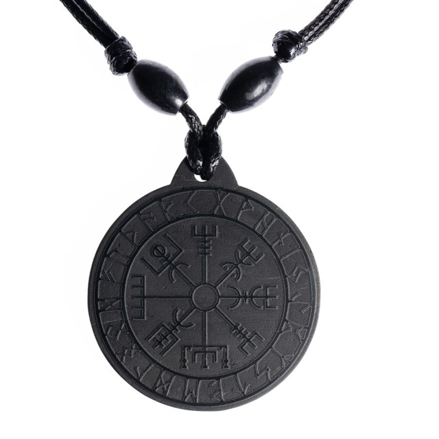 Macro shot of the pendant's face showing the detailed carved pattern of the Vegvisir runic compass on the shungite surface.