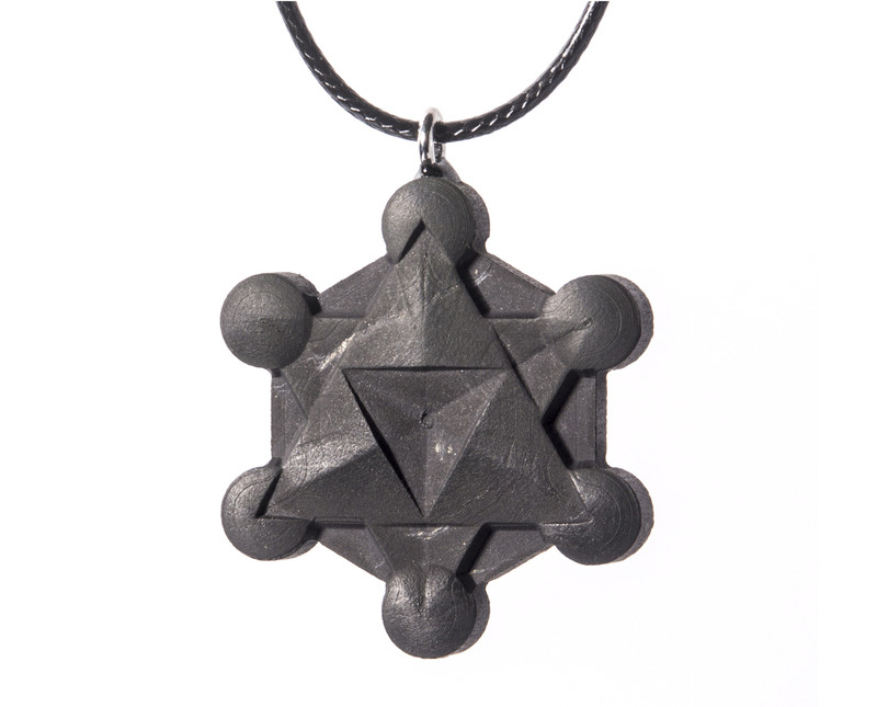 A detailed, three-dimensional Metatron's Cube pendant carved from black shungite on a dark background, showcasing its complex sacred geometry.
