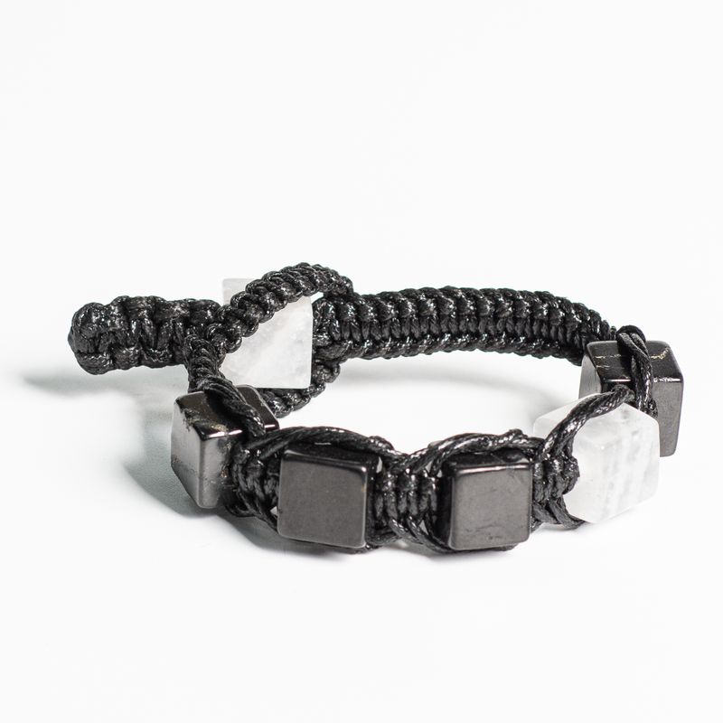 Men's black shungite knot bracelet with white quartz stone inlay, laid flat.
