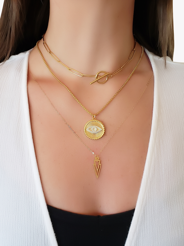 Woman Wearing Gold Layered Necklaces With An Evil Eye Pendant And Geometric Triangle Design | Mojo Supply Co