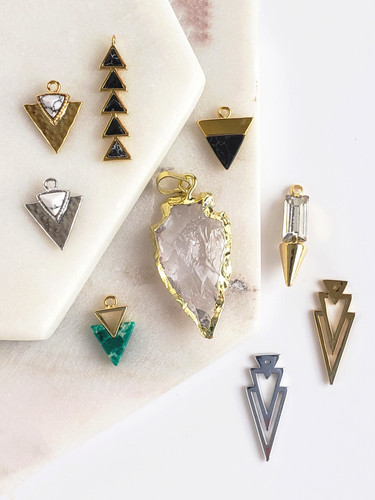 Collection of 9 Arrow Triangle Shape Earring Charms in Various Styles, Metals, and Colors. 1 Gold and White Howlite Arrow Earring Charm. 1 Silver and White Howlite Stone Earring Charm. 1 Gold and Turquoise Arrow Earring Charm. 1 Black Marble Multi Triangle Long Drop Earring Charm. 1 Clear Crystal and Gold Arrowhead Charm Pendant. One Dainty Black and Gold Triangle Arrow Earring Charm. 1 Dainty CZ and Gold Spear Earring Charm. 1 Gold and 1 Silver Long Double Arrow Earring Charm. | Mojo Supply Co