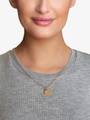 Woman Wearing Dainty Gold Carved Disc Letter Necklace