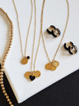 Dainty Gold Coin Initial Necklaces Laying With Black Huggie Hoops and Dainty Birthstone Charms
