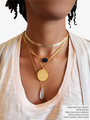 Woman Wearing A Gold Arrow Chain Choker And Three Gold Filled Necklaces Layered With A Blue Gemstone Connector, A Gold Coin And A White Quartz Gold Teardrop Pendant | Mojo Supply Co