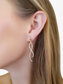 Woman Wearing A Classic Gold Round Stud Earring Paired With A Gold And White Ribbon Tie Charm | Mojo Supply Co