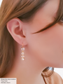 Woman Wearing A Gold Hook Earring Layered With A  Gold Three-Stone CZ Charm| Mojo Supply Co