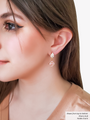Woman Wearing A Gold Crystal Stud Earring Paired With A  Gold Pink CZ Diamond Charm | Mojo Supply Co