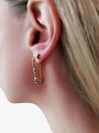 Woman Showcasing Clancy Safety Pin Rainbow Cubic Zirconia EarringsWith Classy Aranza Green Baguette Stud | Mojo Supply Co