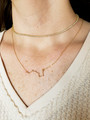 Woman Wearing Layering Necklaces Including Allie Cubic Zirconia Crystal Choker And Brianna Dainty Chain Necklace Accentuated With Barbara Zodiac Constellation Pendant | Mojo Supply Co