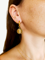 Woman wearing gold earrings. First earring is small gold cuff and second earring is a thick Waylon hoop with a slide on celestial sun charm with etched sunburst details | Mojo Supply Co