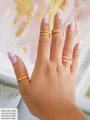 Chevron Stacker Rings With Hammered Gold Stackers and Pink Eternity Rings Stacked on a Beautiful Hand with Manicure Hand