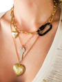 Women Wearing Gold Layered Necklaces With Black Kenya Carabiner Lock Necklace Pendant And Heart Shaped Lockets