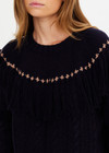 THE UPSIDE women’s navy Clara Tassle Knit Sweater is a relaxed, cable knit design featuring knotted tassels on front and back. Designed for Après-ski and winter wear.