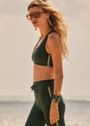 THE UPSIDE women’s green Maneki Jetta Racerback Bra features a V-neck in recycled fabric, removable cups, and elastic underbust support. Made for yoga and pilates.