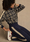 THE UPSIDE women’s navy organic cotton Cosmo Kairo Half Zip Knit is a relaxed fit and features a half zip front and beige knitted stripes down sleeves. Made for everyday leisure.