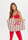 THE UPSIDE women's stripe organic cotton Baja Rhodes Tote Bag features tubular straps and a yarn-dyed cream and burnt red stripe design.