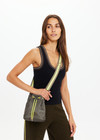 THE UPSIDE women's olive green Oxford Bucket Bag features a striped woven strap and neon paracord with gold metal detailing. Made for lifestyle.